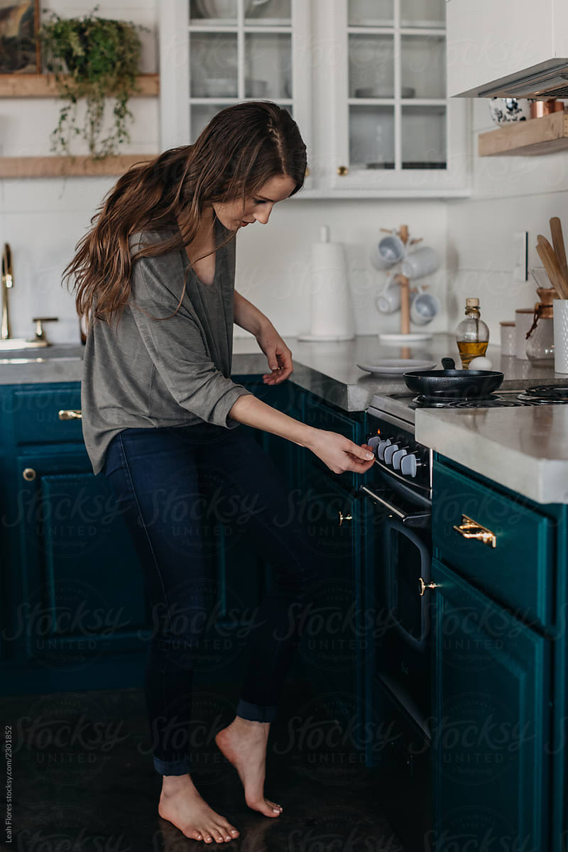Woman Turning on Stove
