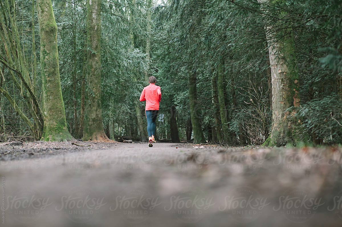 A runner running on a path through the forest