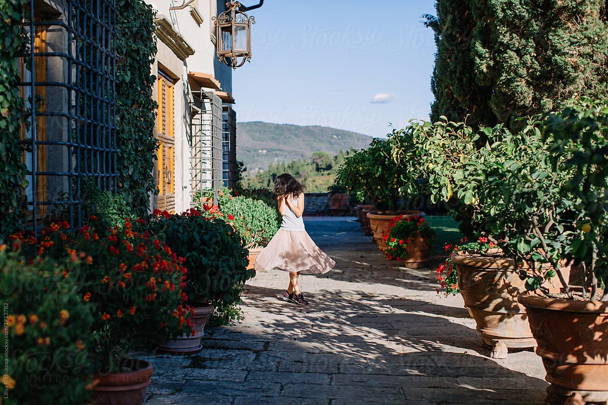 Young cheerful woman swirling in lovely place in Italy