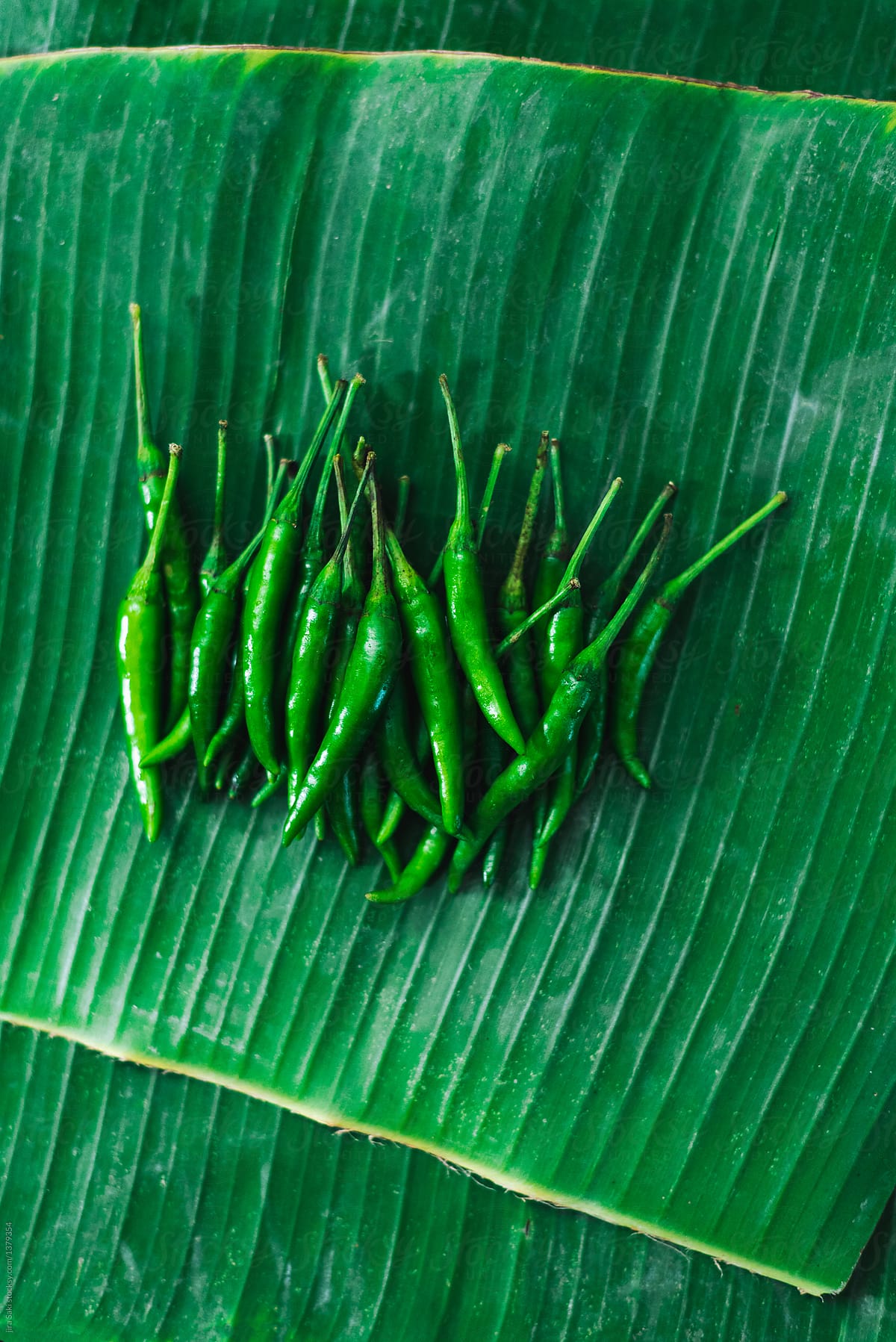 young green chilli on banana leaf