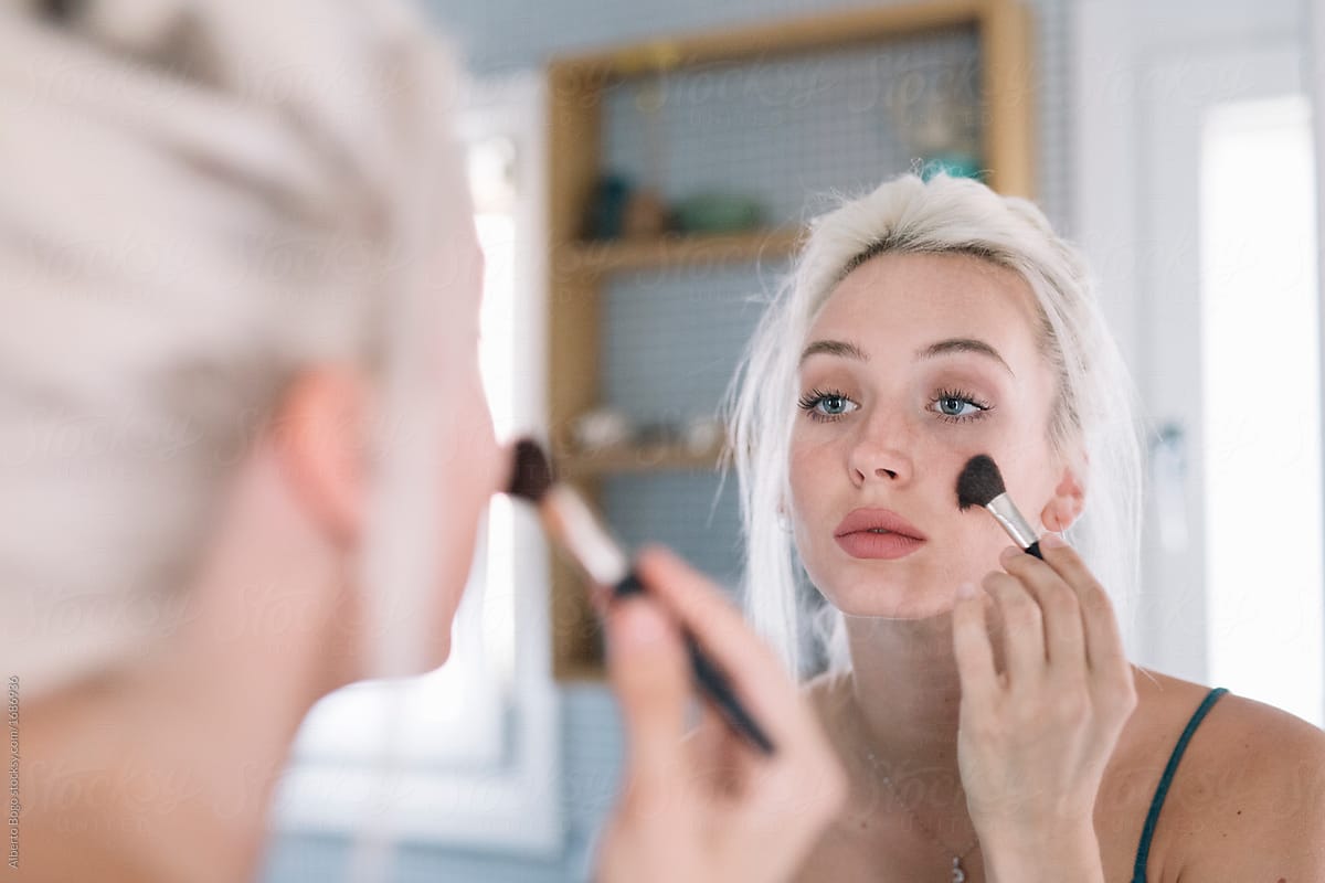 Young model applying makeup