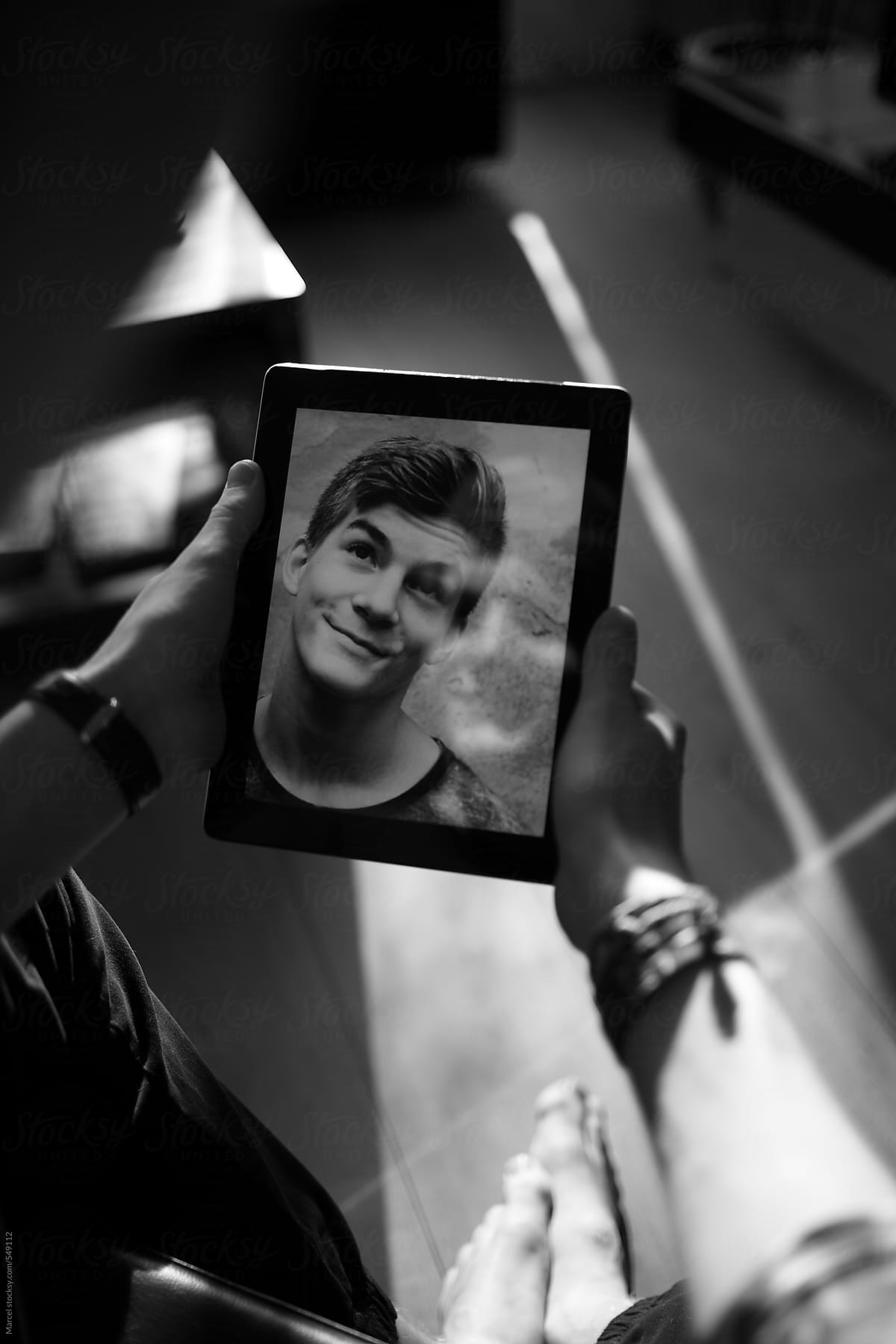 Teenage boy looking at a selfportrait on a tablet computer
