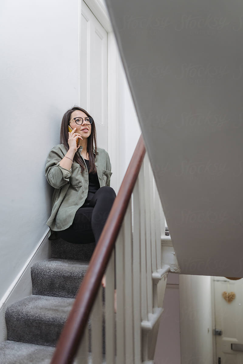 Woman making phone call on staircase
