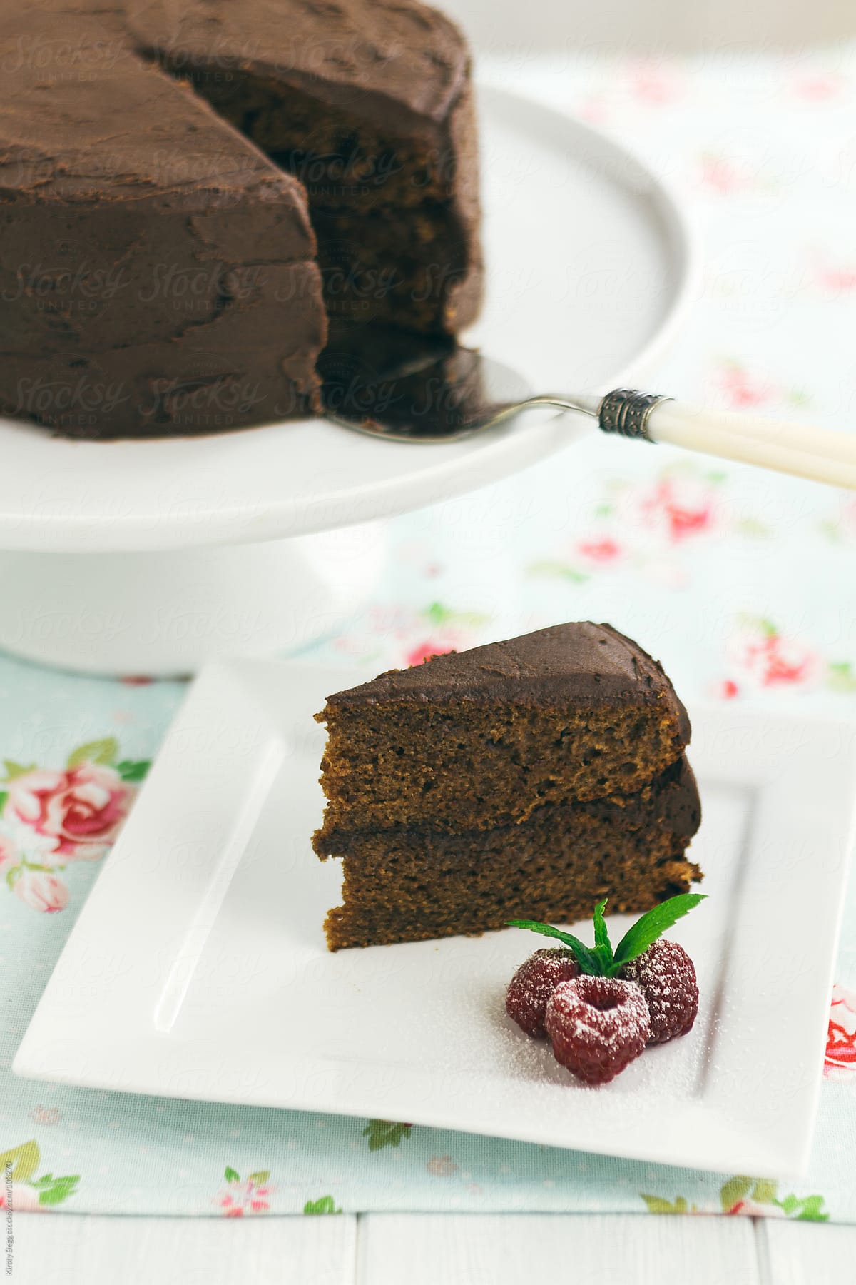 Slice of chocolate buttercream  chocolate cake with raspberries