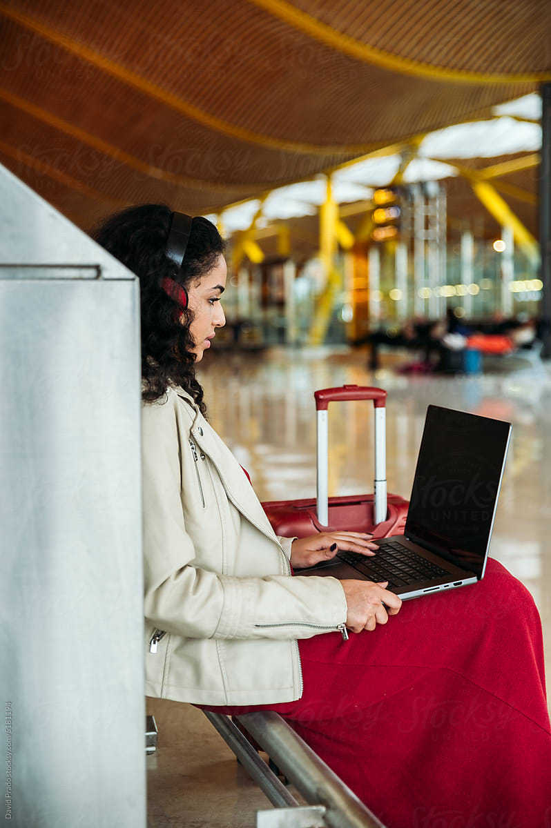 Positive woman using netbook in airport