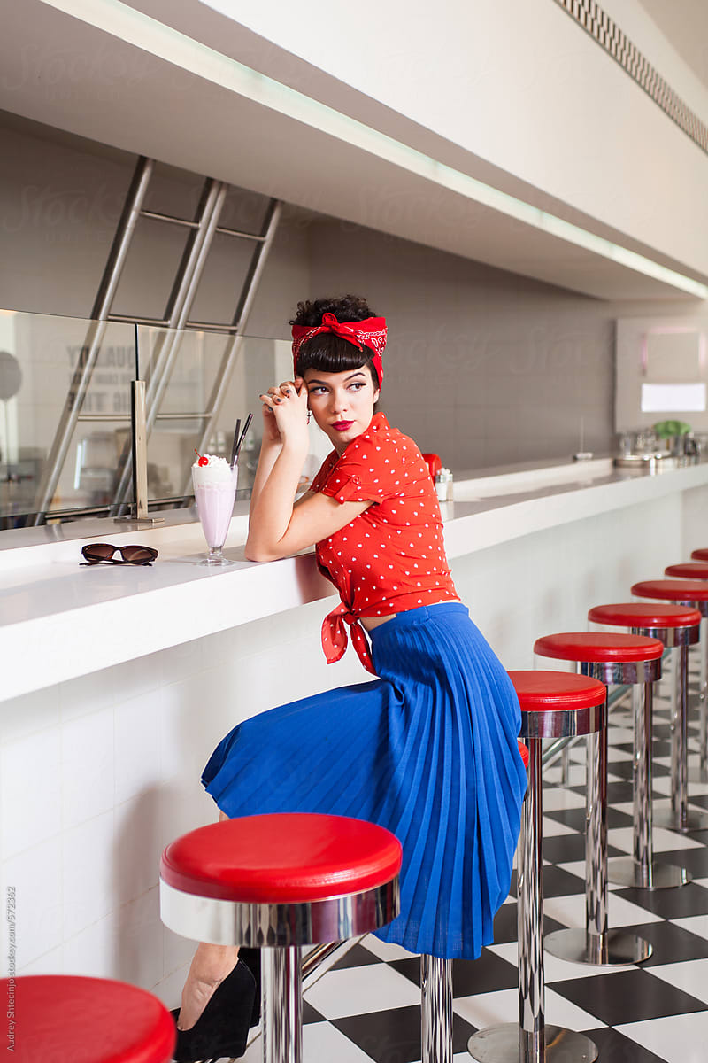 Pin up rockabilly female sitting at retro restaurant  bar from 50\'s.