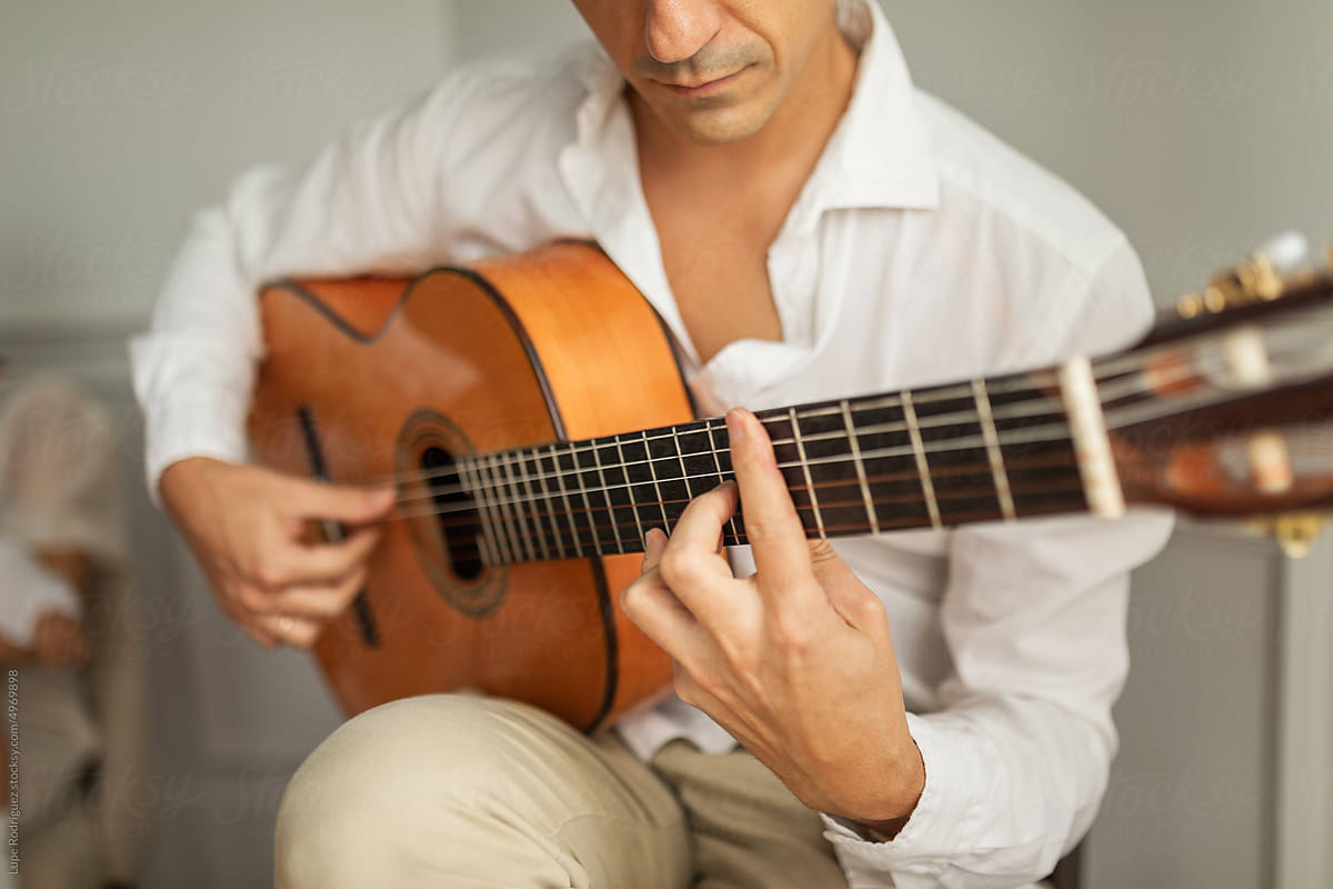 man playing guitar at home