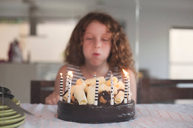 girl blowing out birthday candles