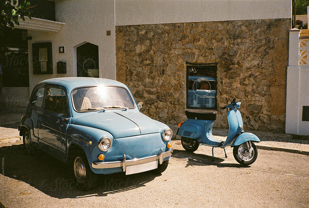 Blue retro car and moped in the street