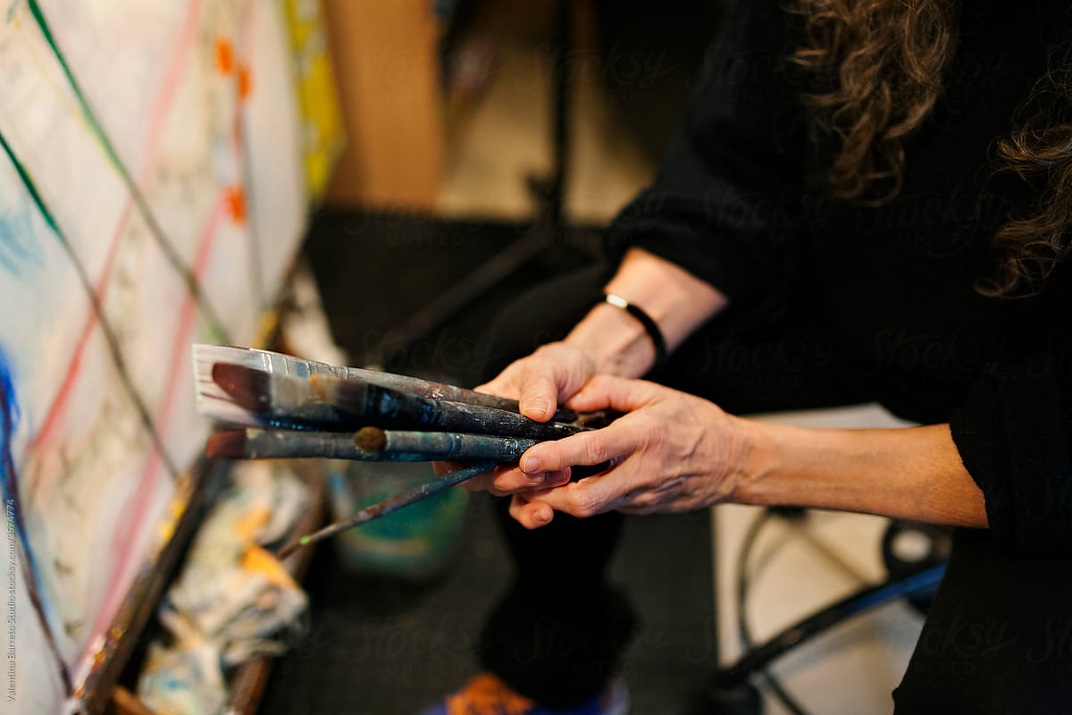 artist hand holding a bunch of brushes i her hands