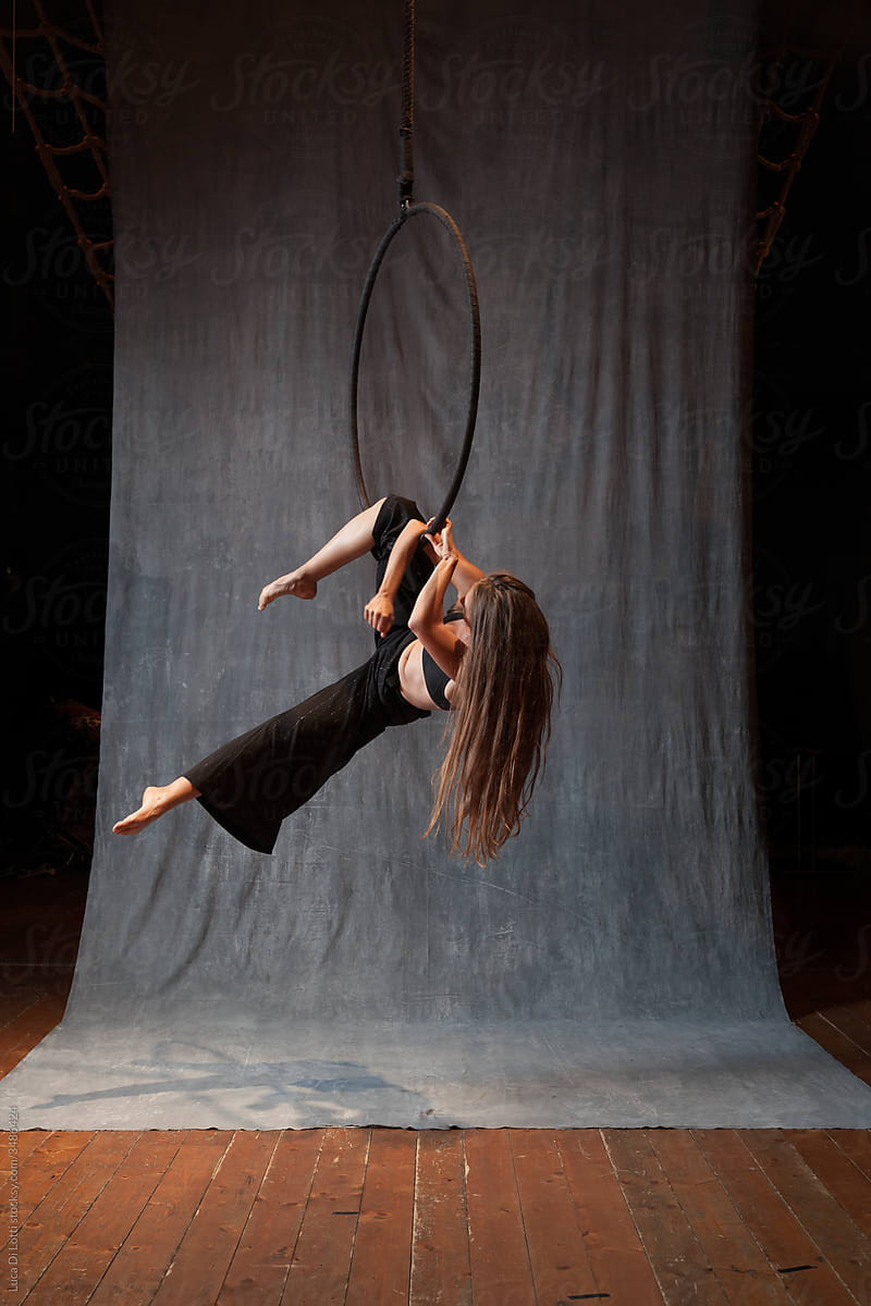 Aerial artist in a beautiful pose on a Lyra or Aerial ring