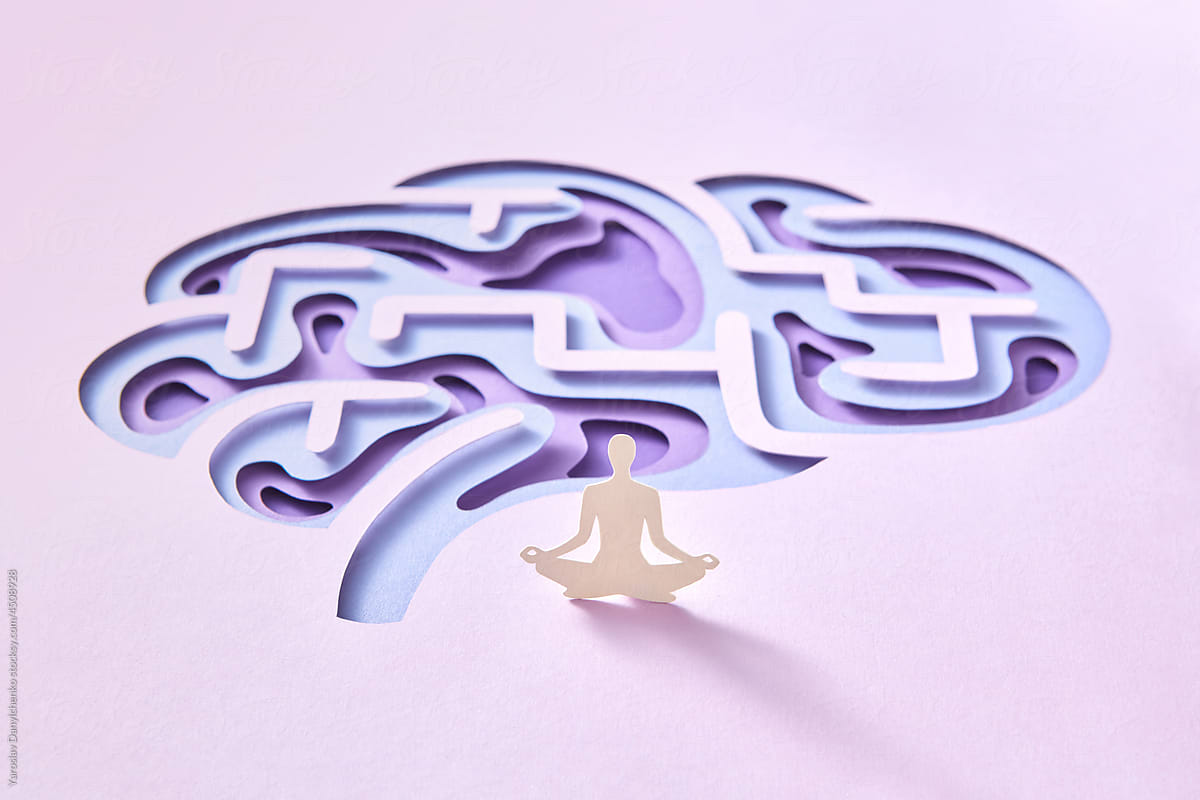 Paper silhouette in lotus pose in front of brain.
