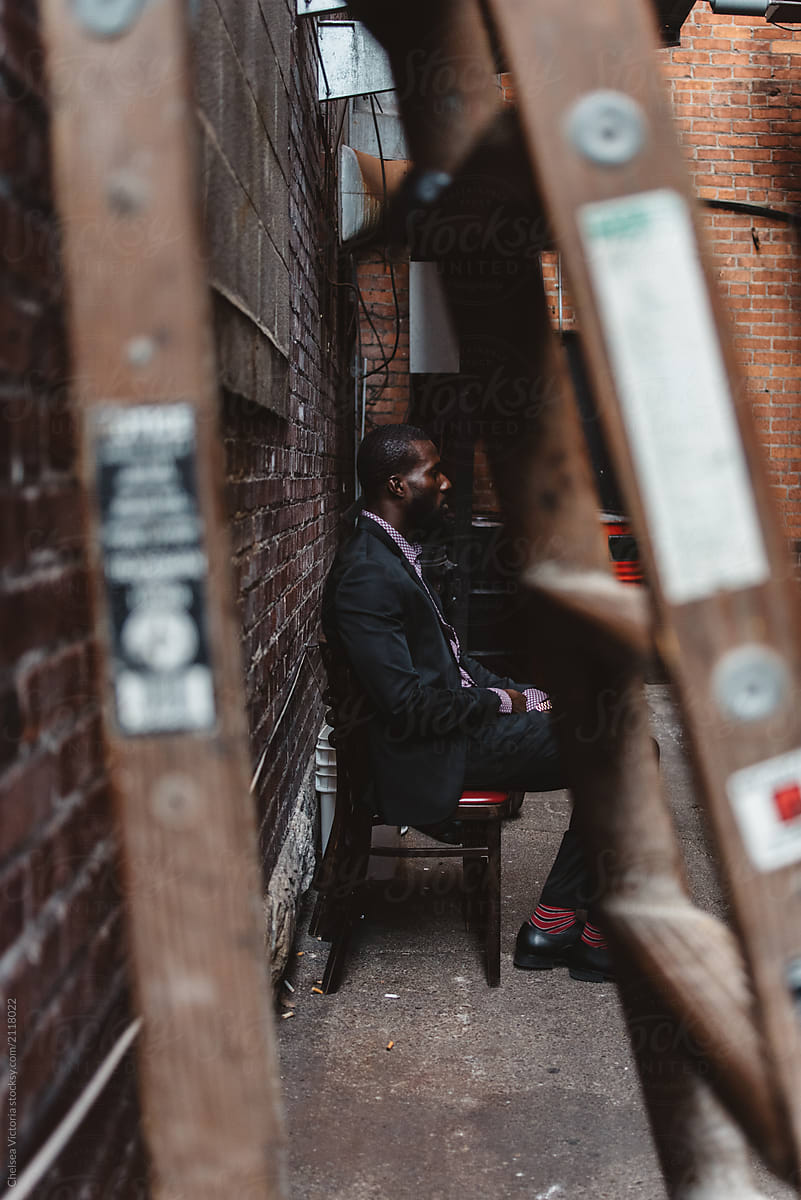 A young black man in the city wearing a suit