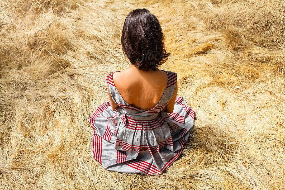 Young Woman with Vintage Dress Sitting on Hay