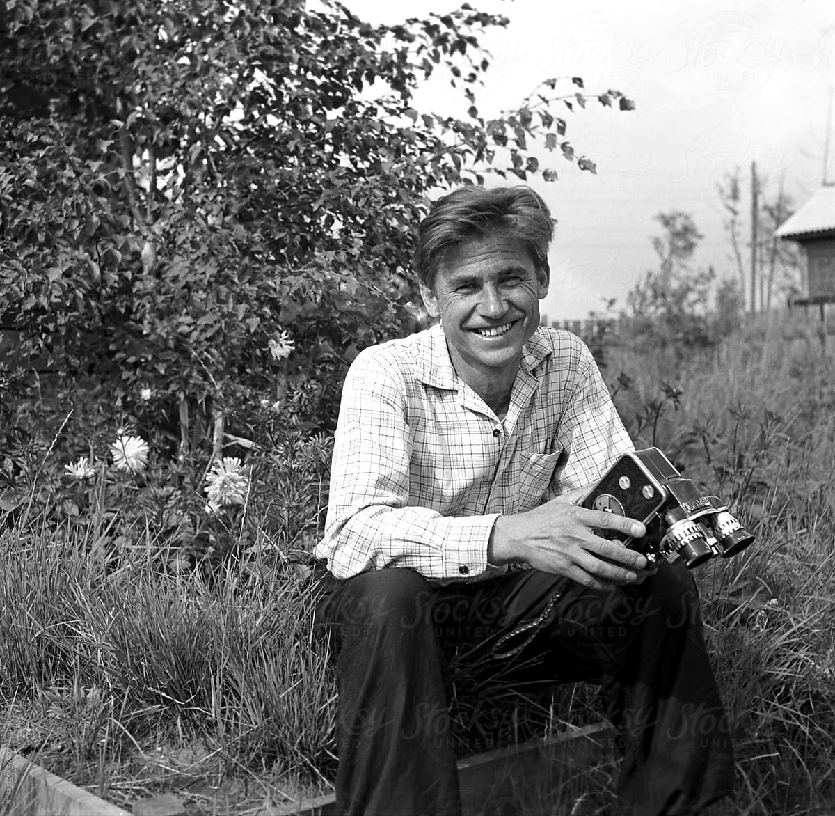 Smiling man with retro film video camera