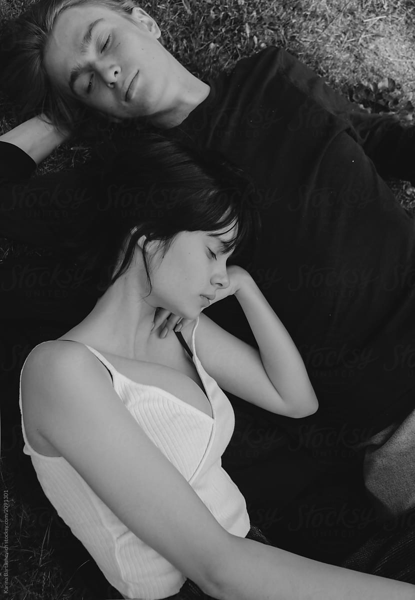 black and white portrait of a couple lying in an embrace on the ground