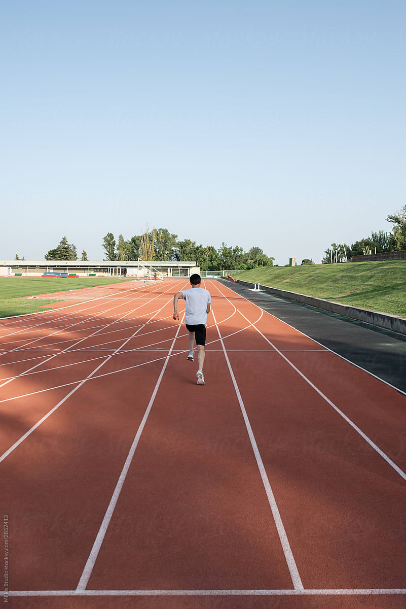 Anonymous athlete running on long racetrack