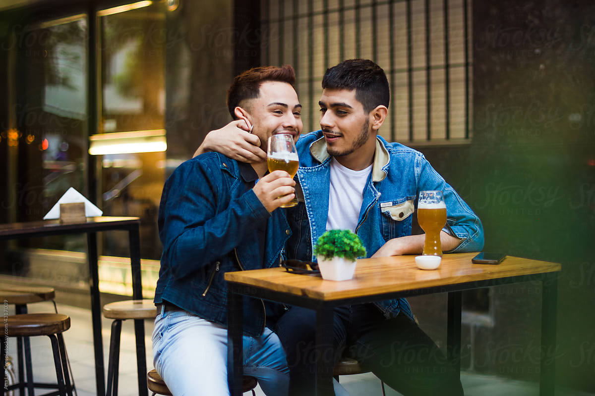 Gay couple having a beer outdoors