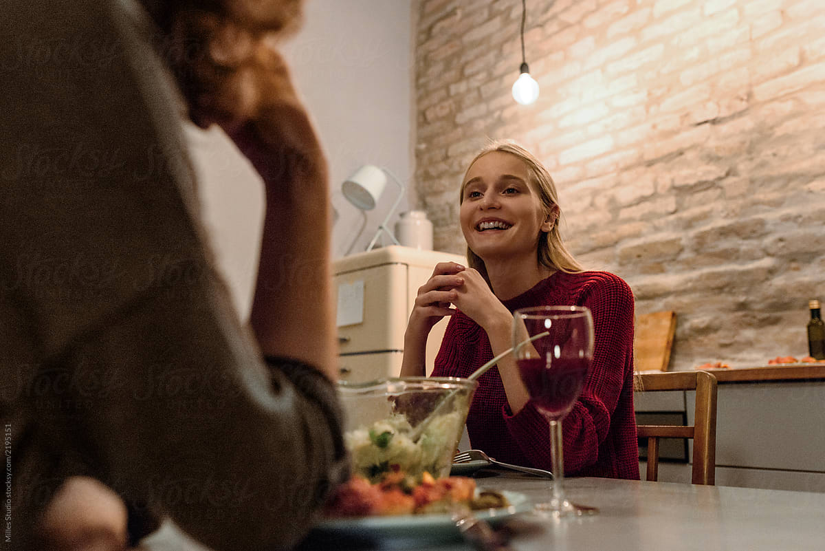 Cheerful Woman With Friend Having Dinner At Home By Stocksy