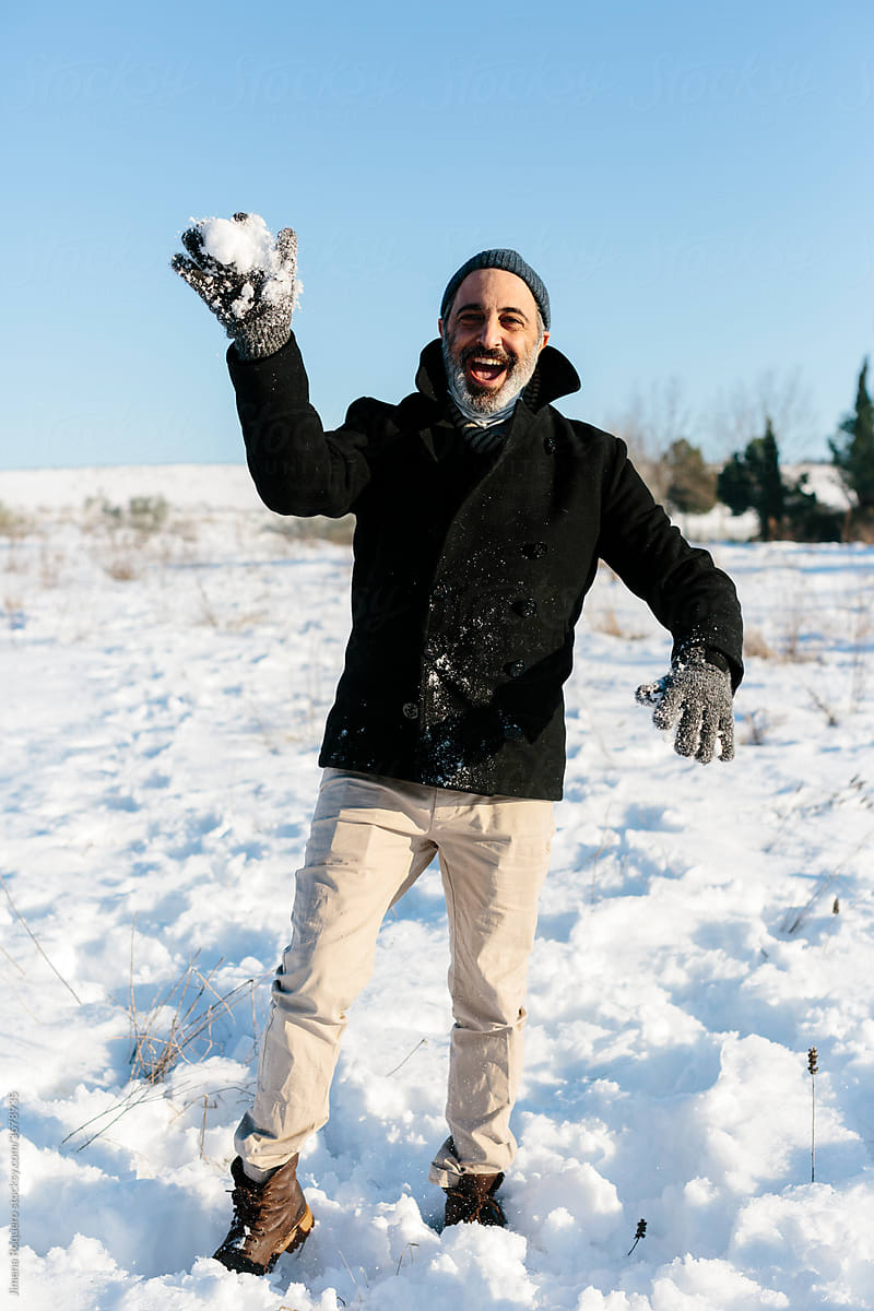 Man throwing a snowball to camera in positive attitude