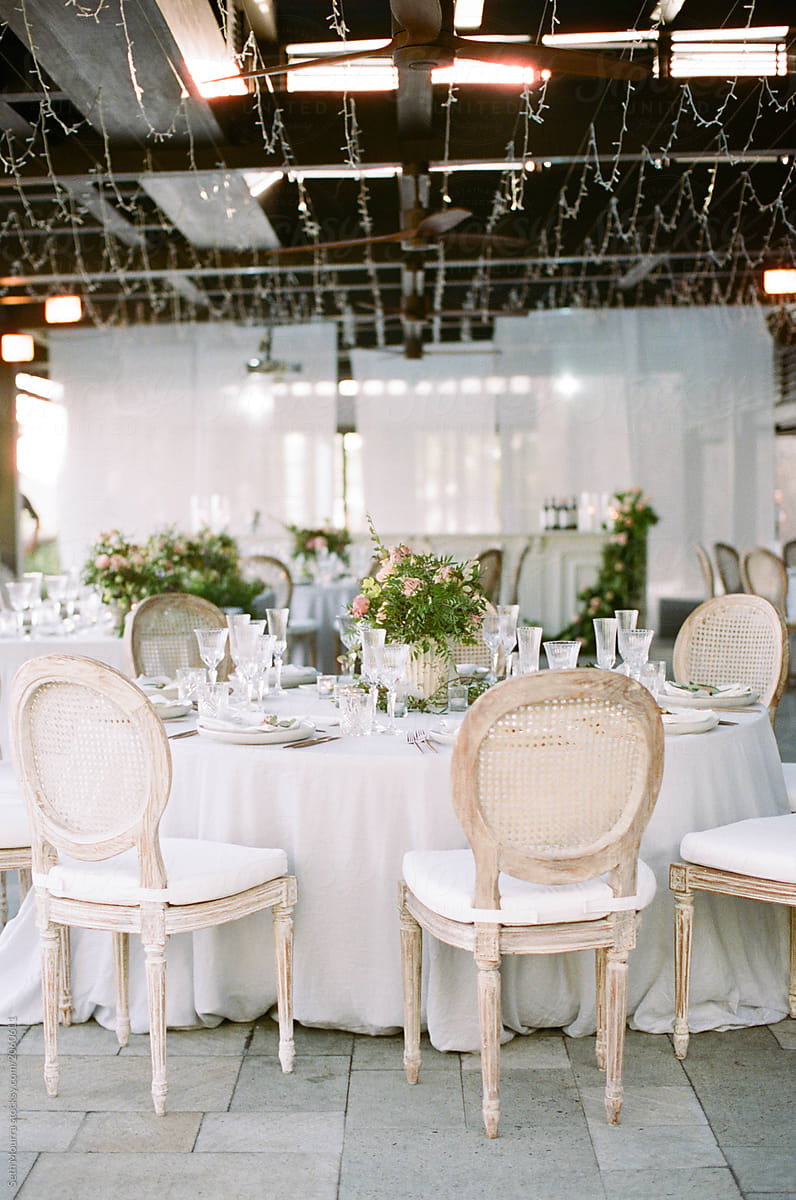 A wedding reception space & table decorated with neutral linens and floral arrangement