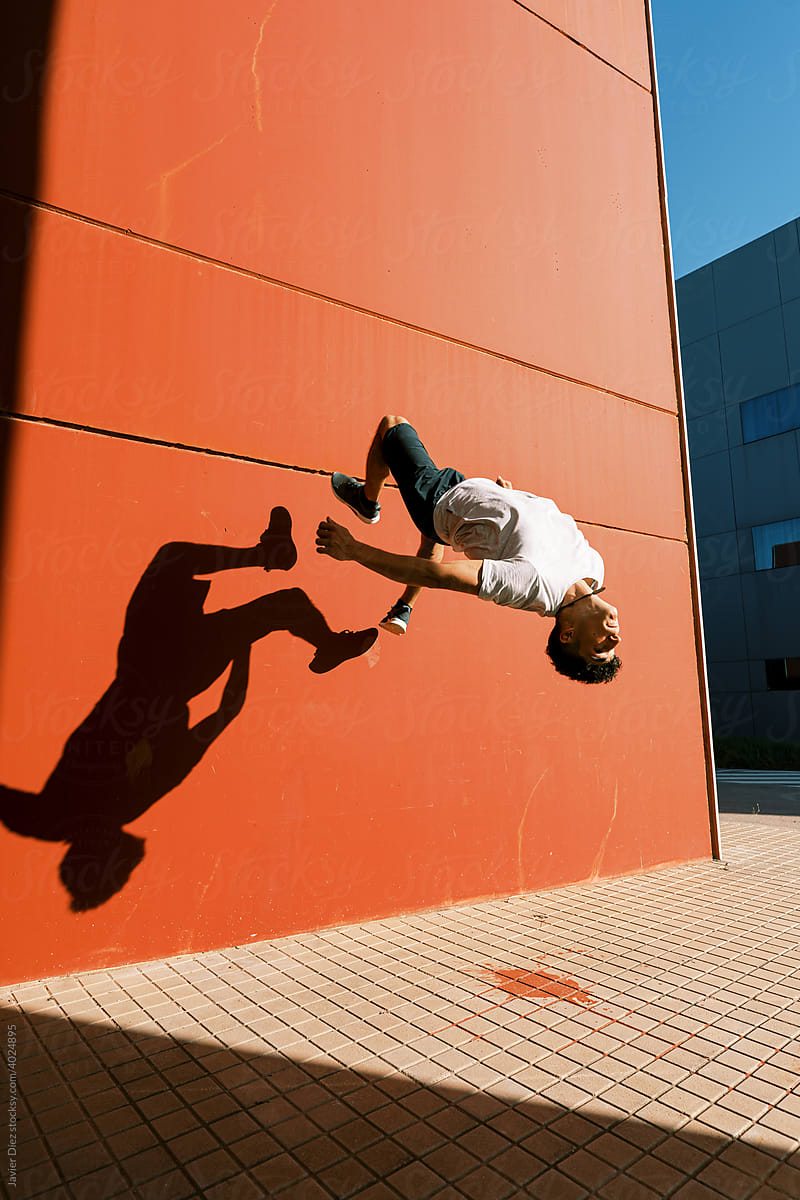 Energetic man performing trick near wall