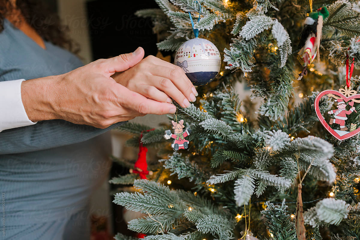 Man caresses his pregnant wife, they\'re decorating a Christmas tree