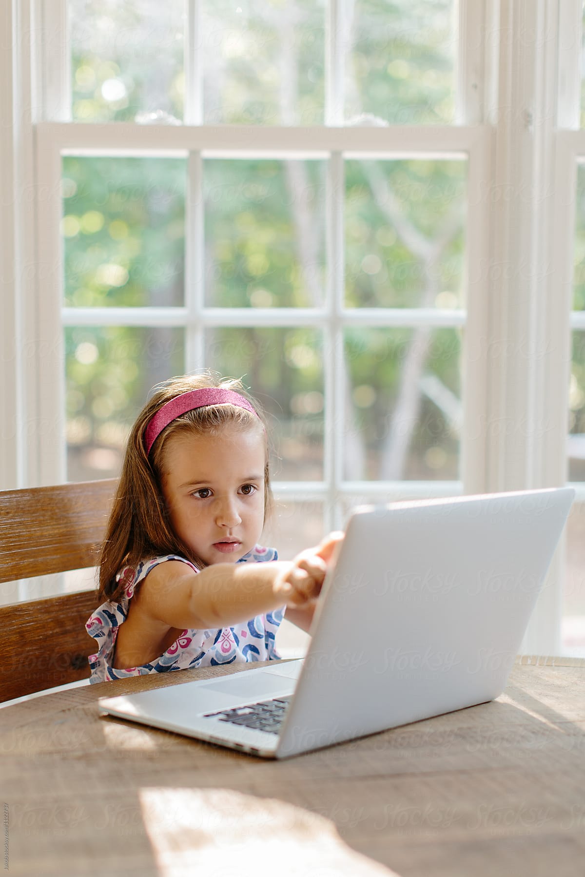 Beautiful young girl touching the screen of a computer