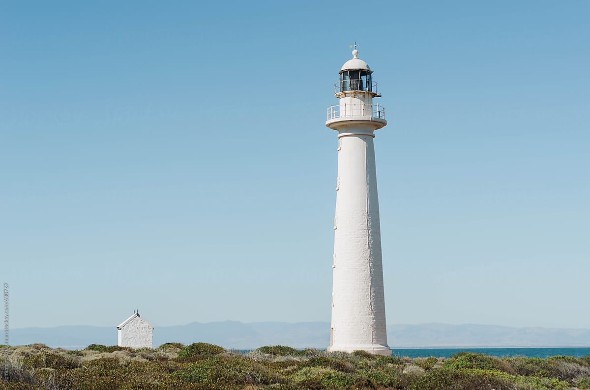 Bright white lighthouse by shallow coastline