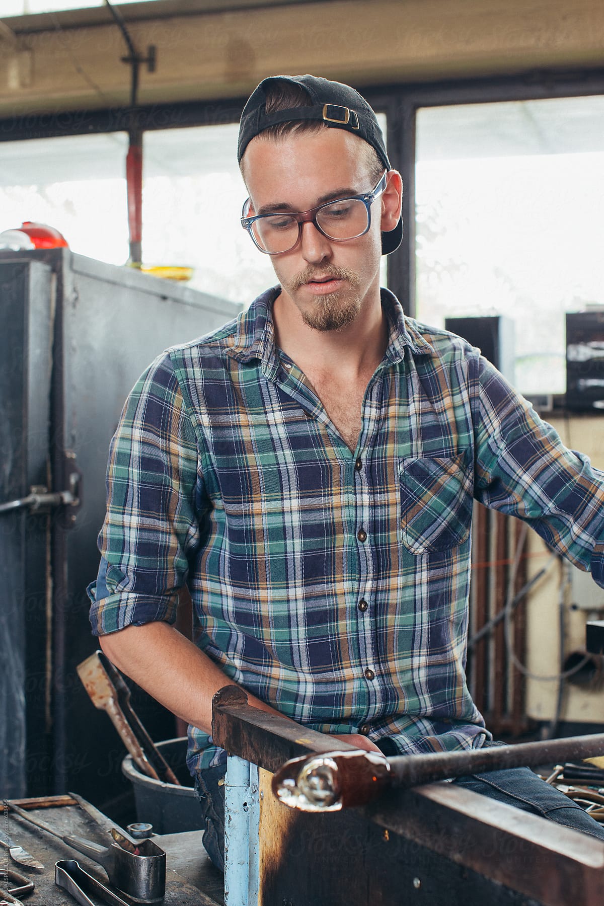 Artisan Glass Workshop - Portrait of Young Good-Looking Male Glass Artist Working Hot Glass
