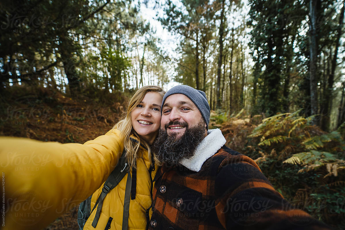 Traveling couple taking selfie in forest
