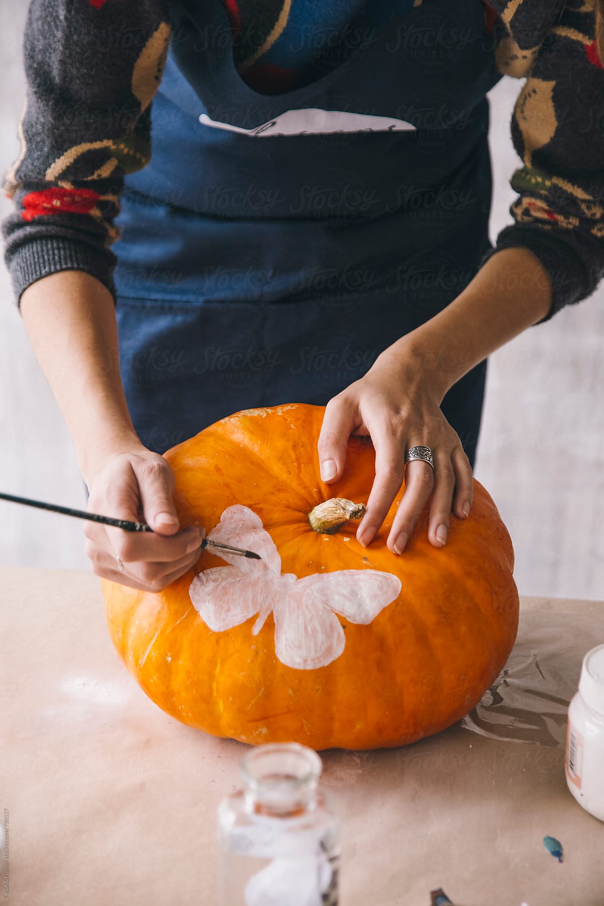 Woman painting on pumpkin using decoupage technique