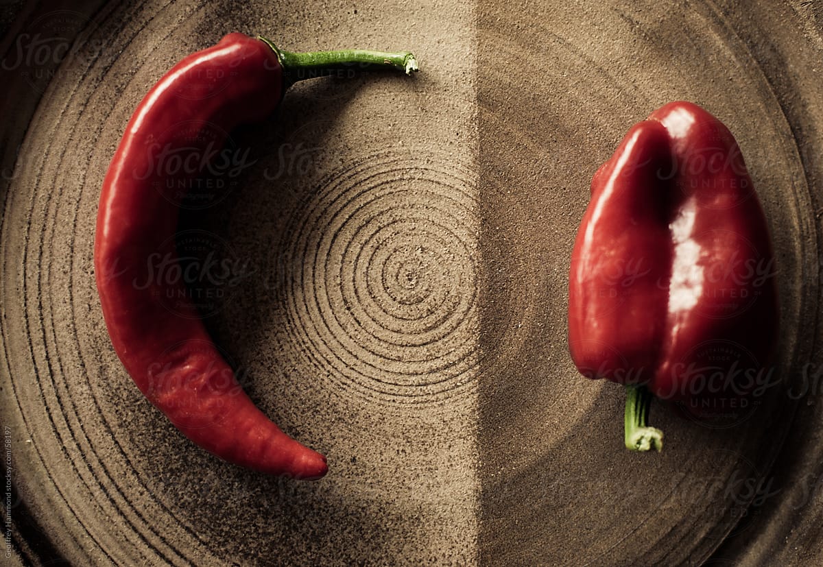 Two Red Peppers on Rustic Ceramic Plate