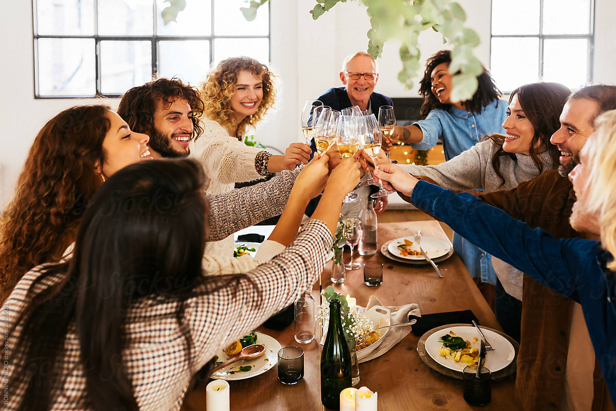 Excited multiracial family clinking glasses during banquet