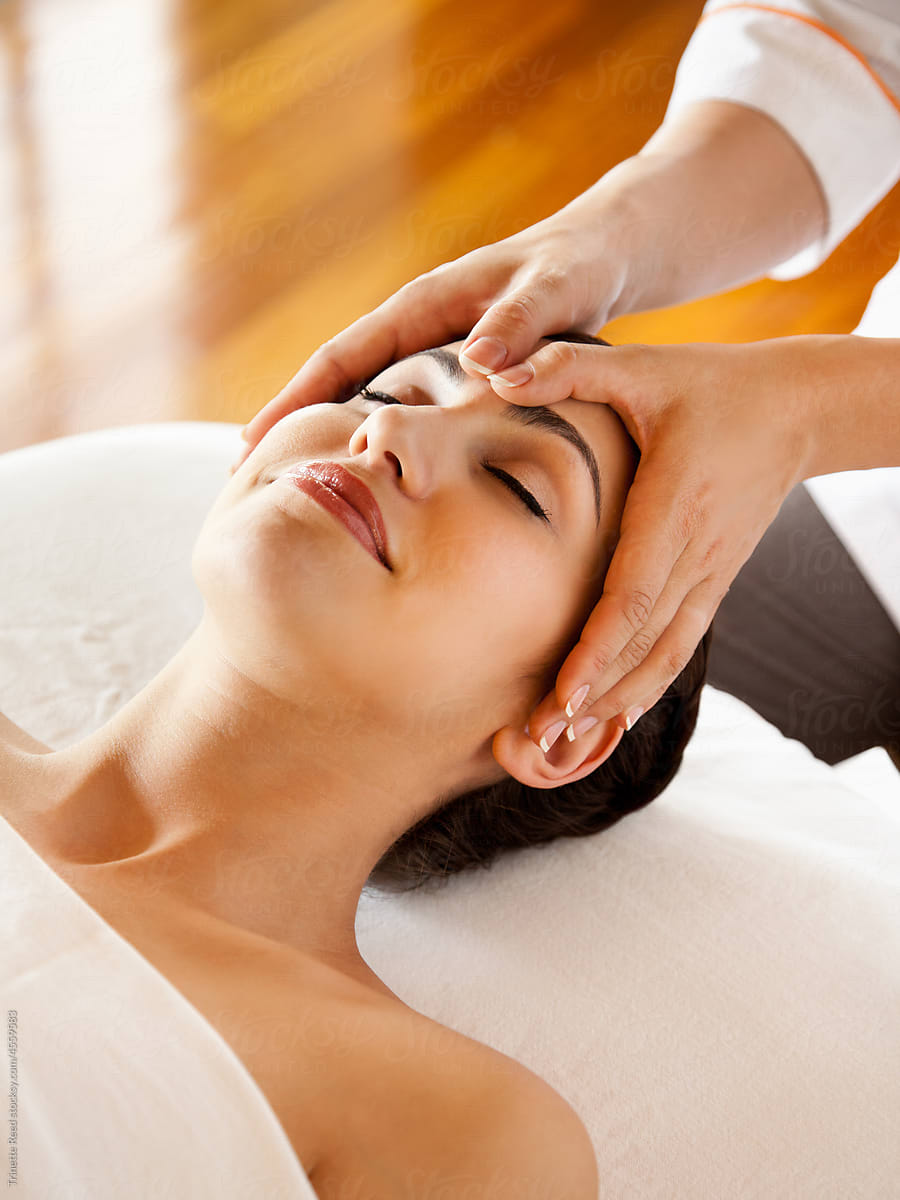 Woman receiving a facial spa treatment massage at luxury spa