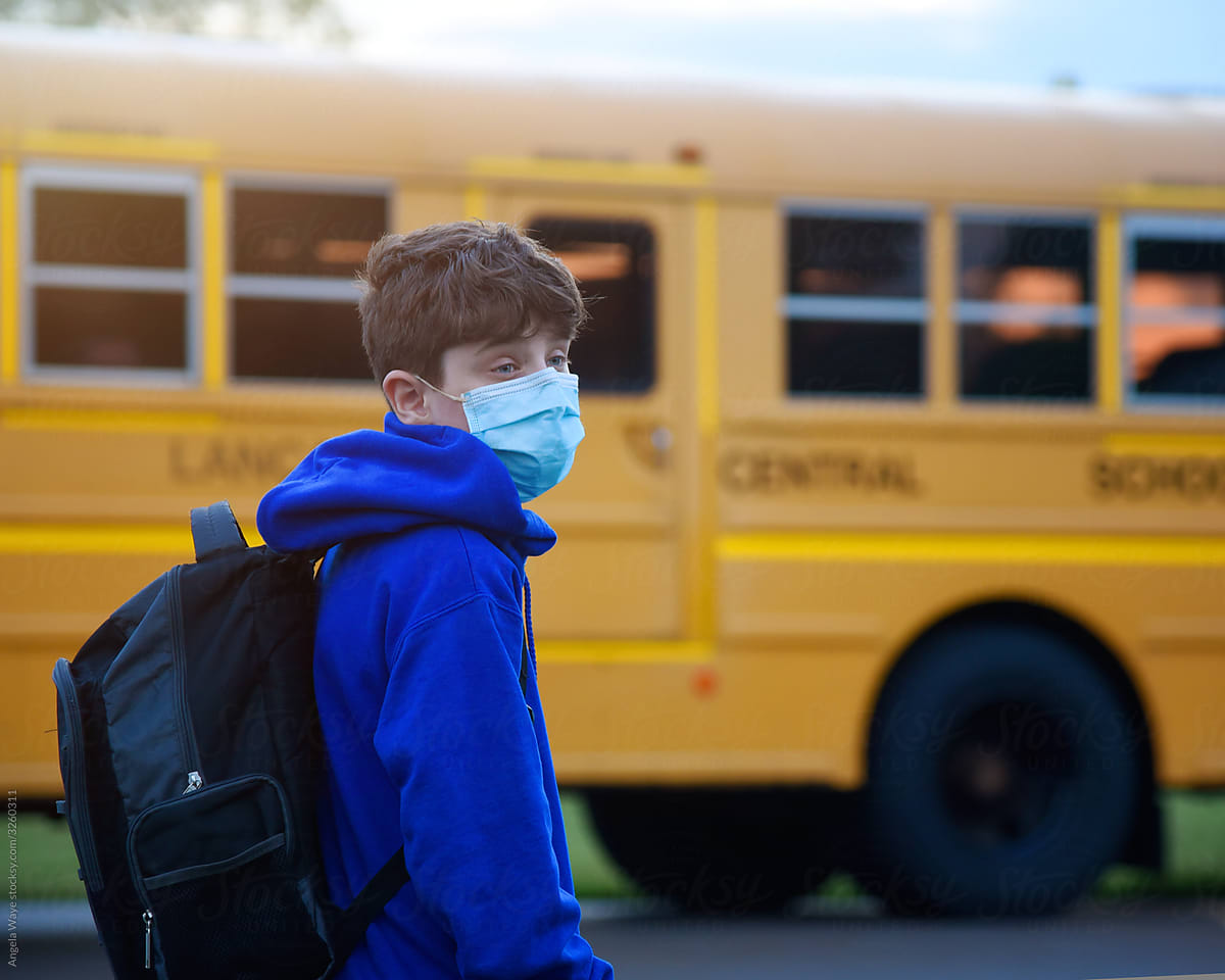 Student Wearing Virus Mask By School Bus