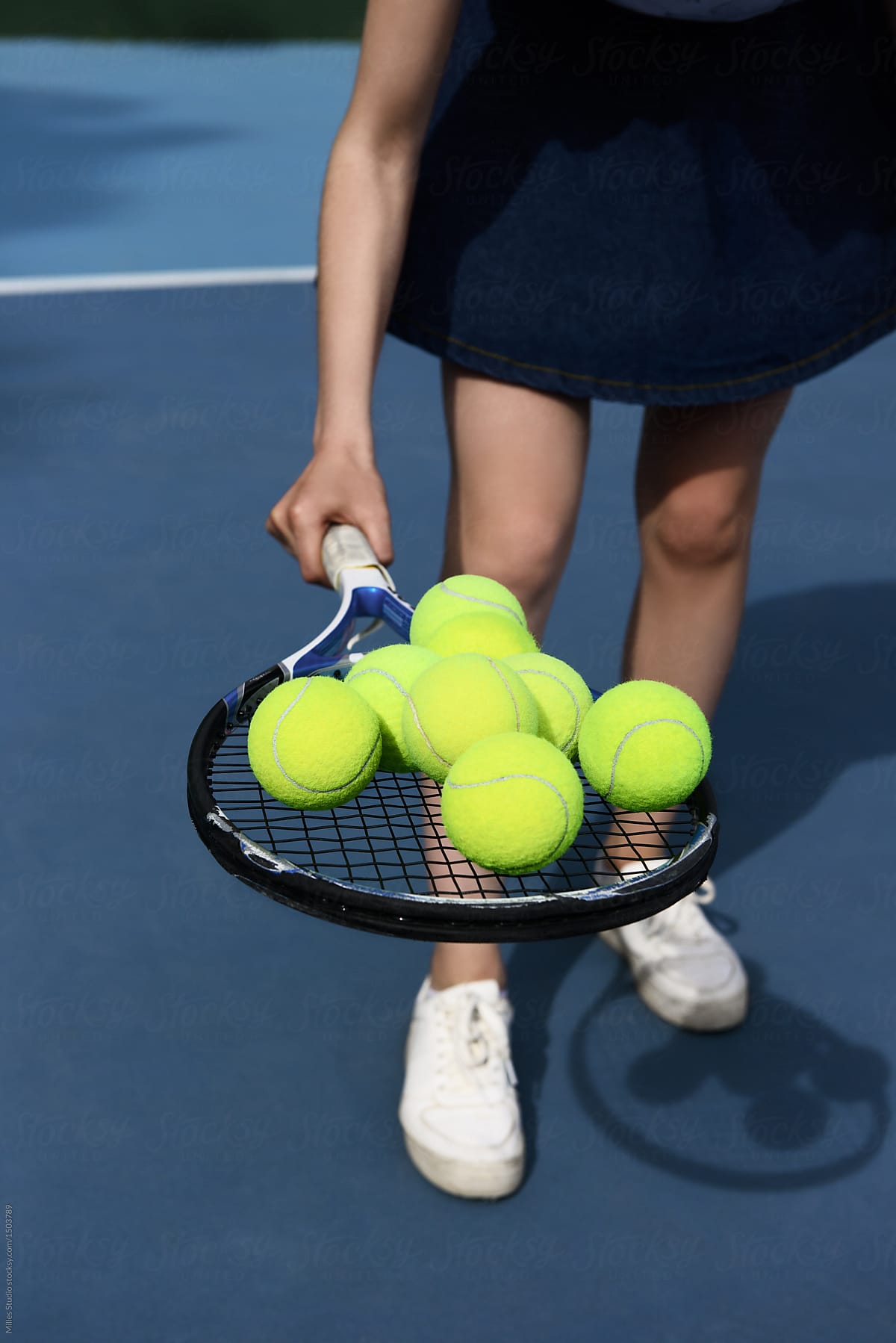 Woman holding racket with balls