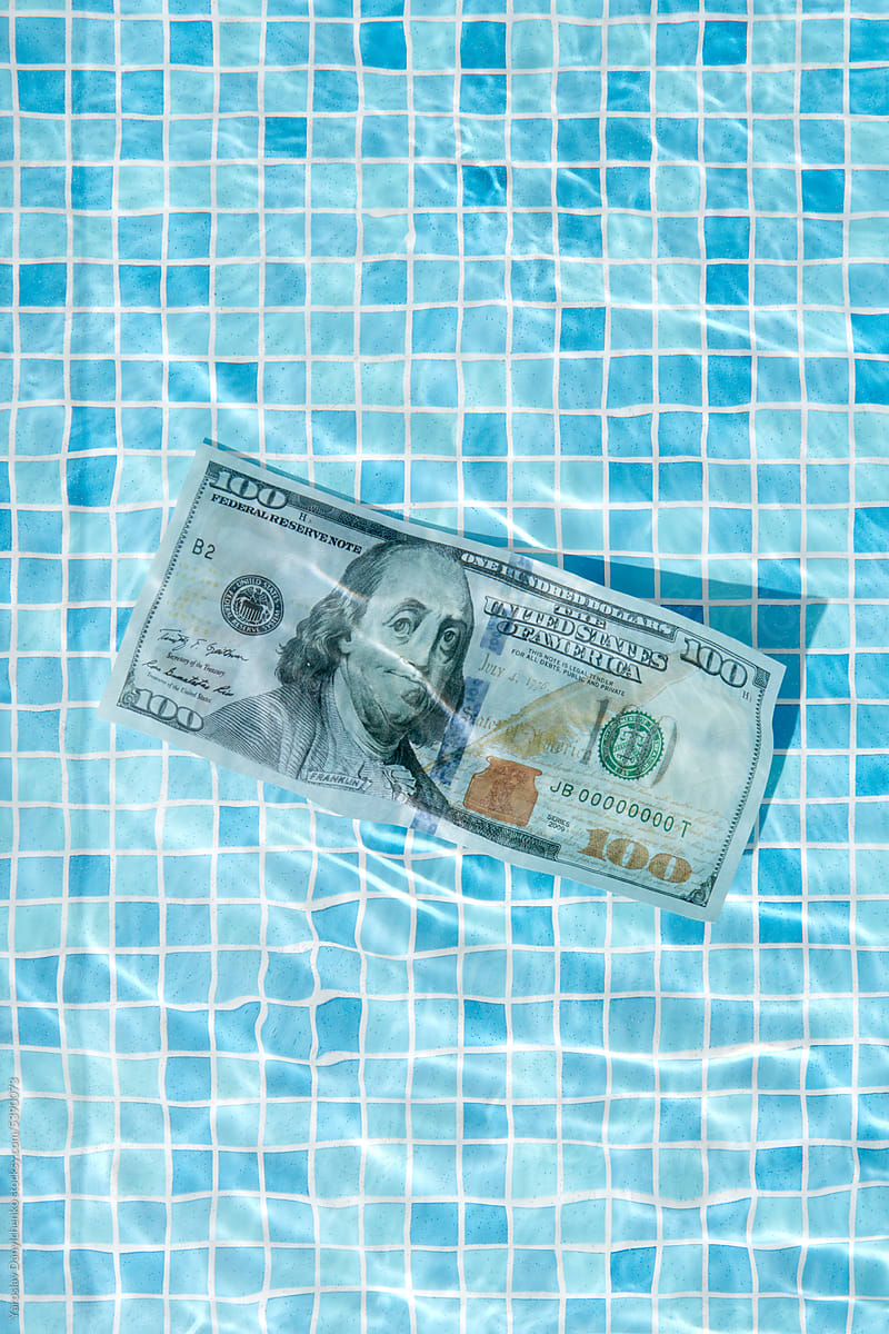 100 dollar bill floating in pool water.