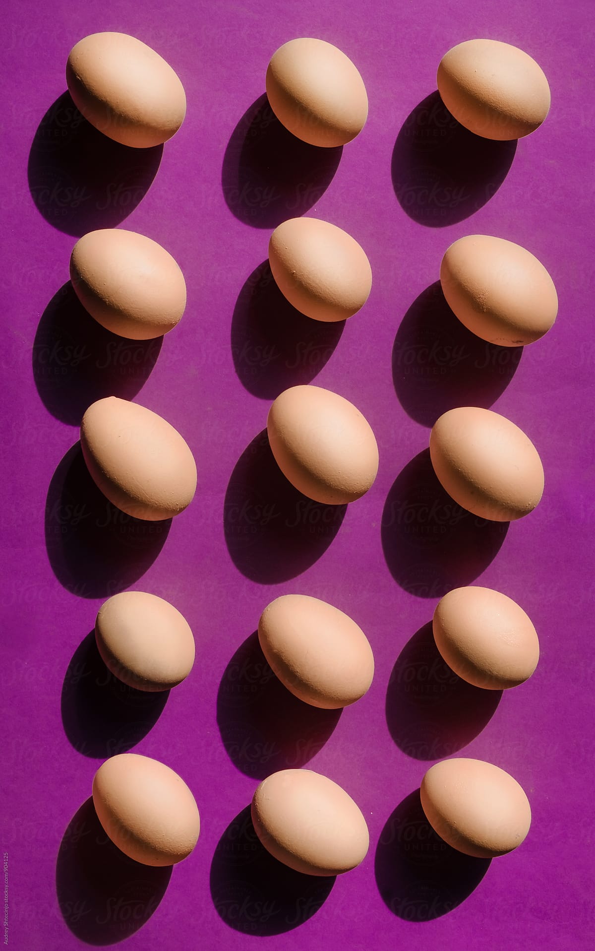 Well organised bunch of eggs on purple background