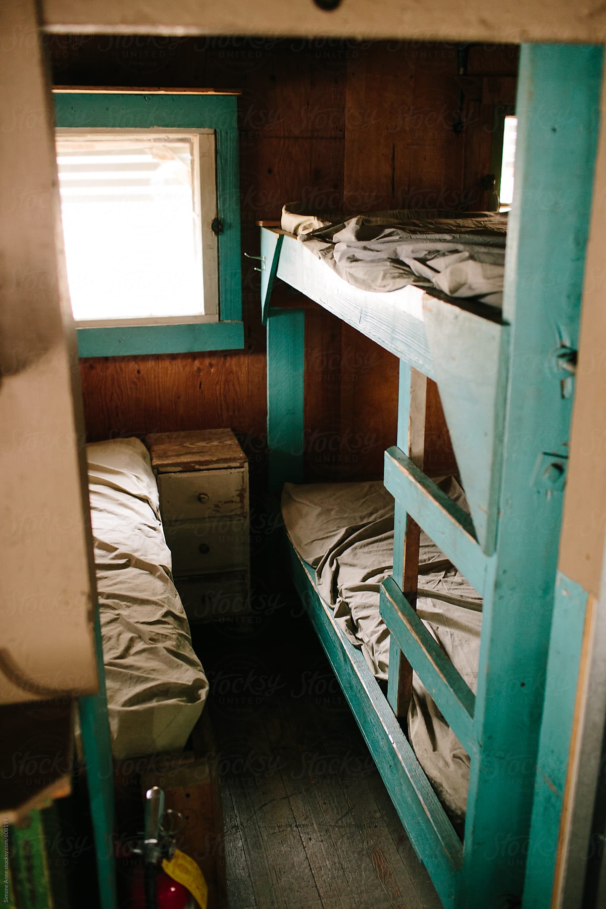 Simple wooden bunk beds with rumpled sheets