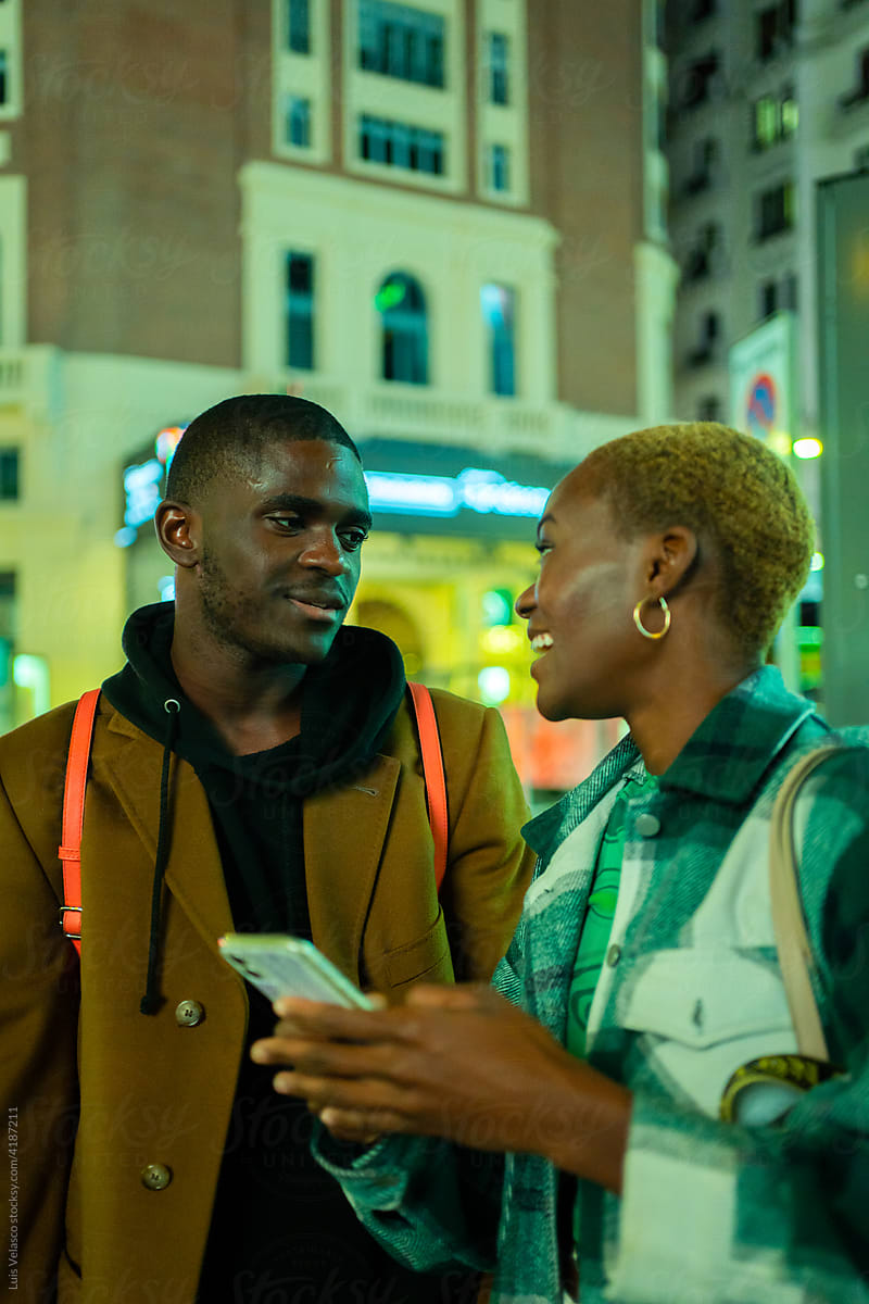 Black Couple With Phone On The Street At Night.