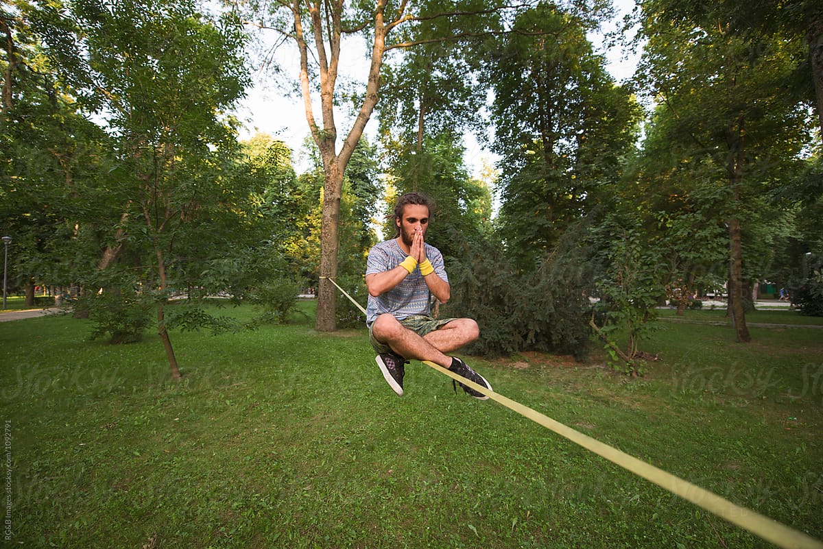 Young Man Sitting In Lotus Position On Slackline by Stocksy Contributor  Ibex.media - Stocksy