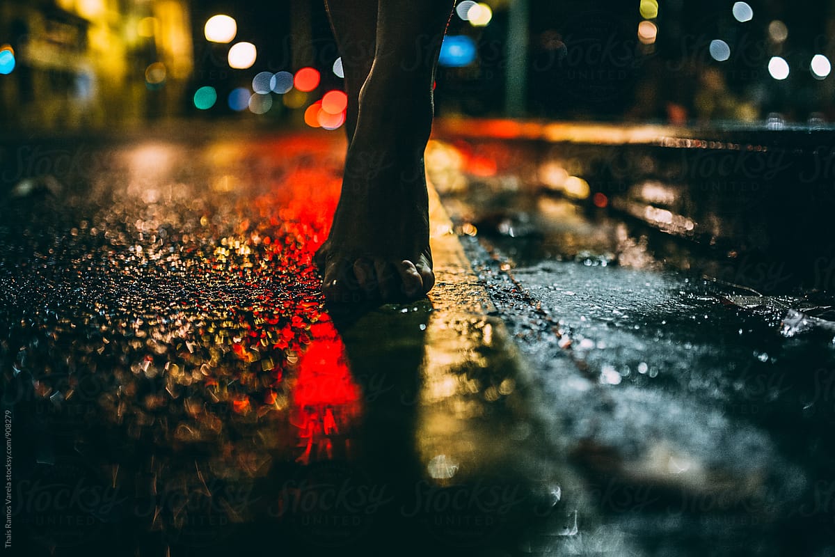 feet on wet road at night