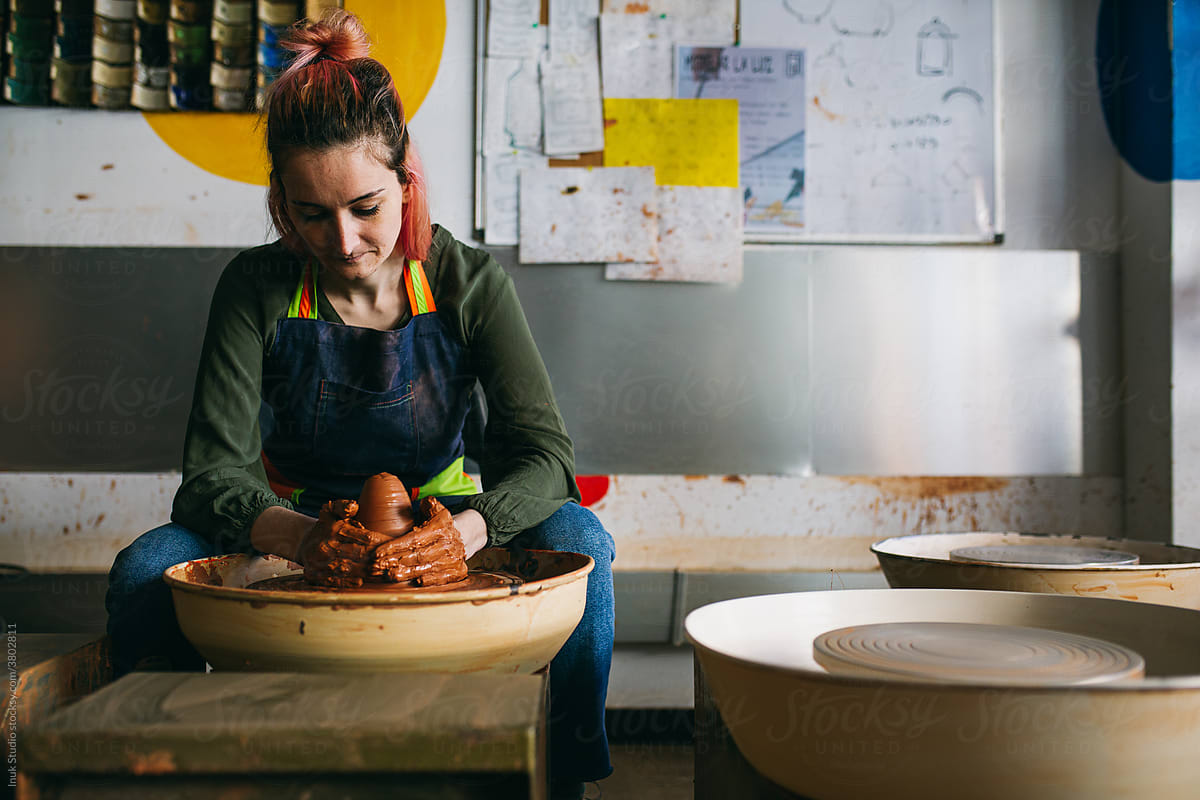 Female potter working with clay on wheel