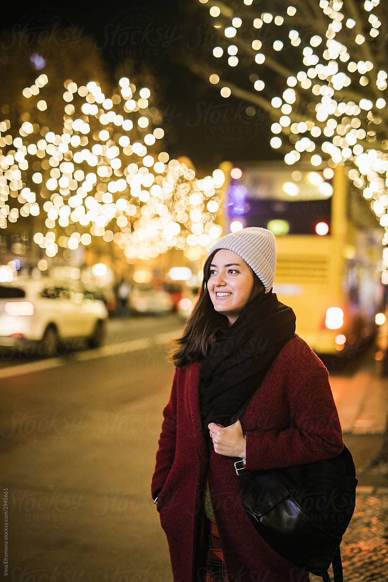Woman waiting for the bus on the illuminated street