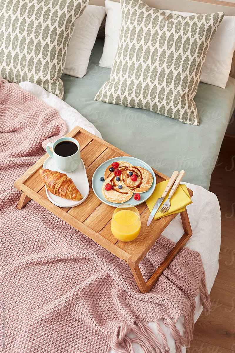 Wooden tray with tasty homemade breakfast.