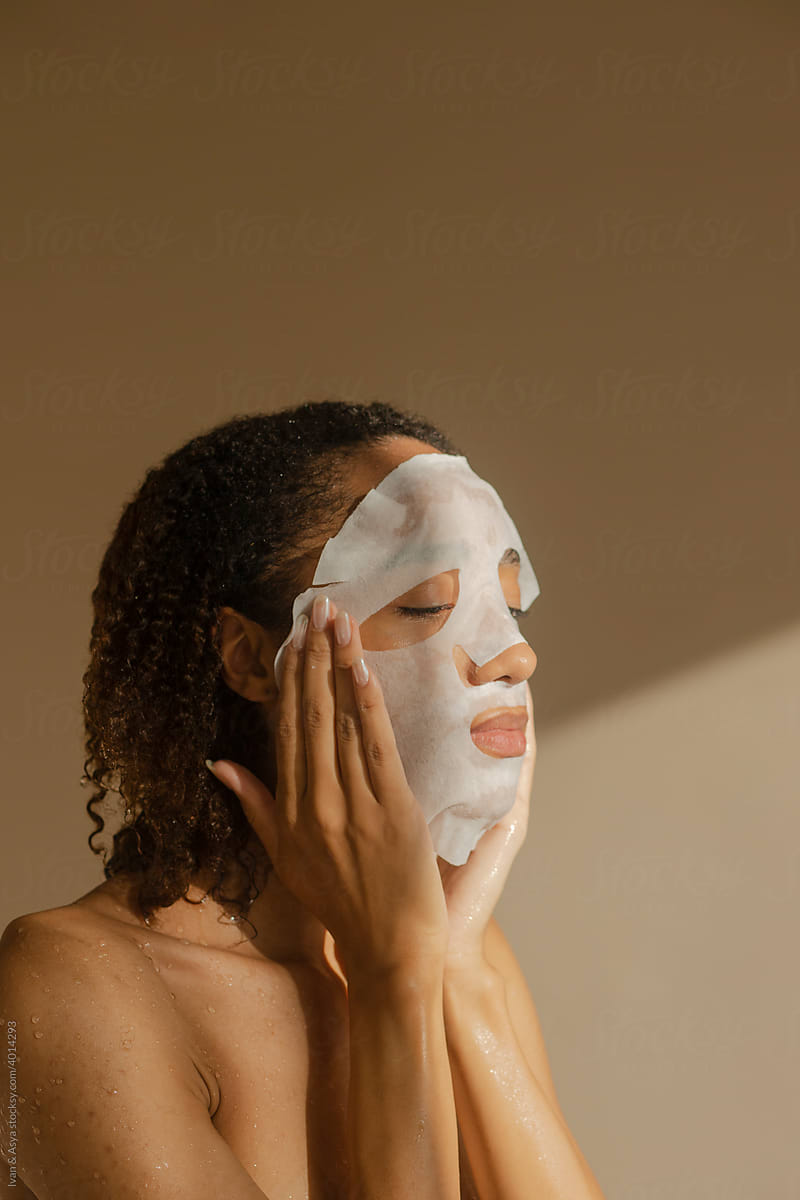 Portrait of female using Cloth Cosmetic Mask for skincare routine