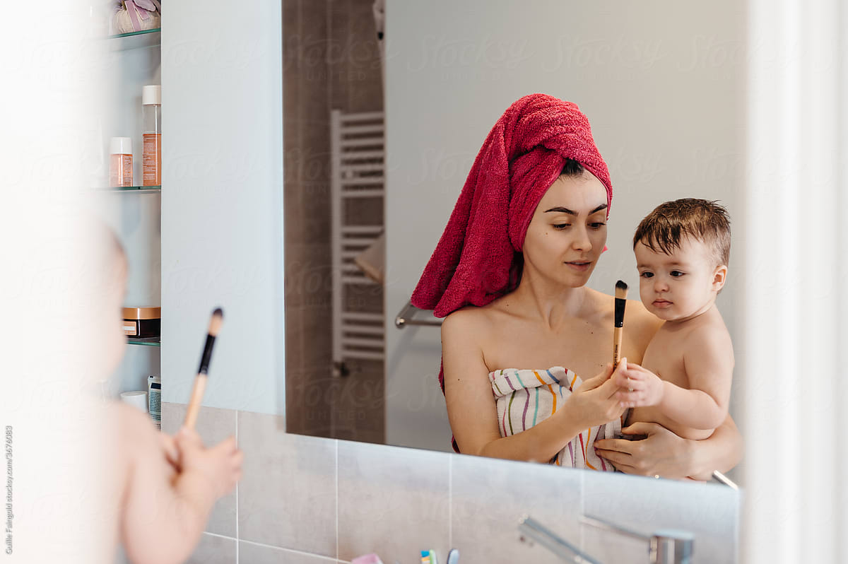Mother showing makeup brush for baby.