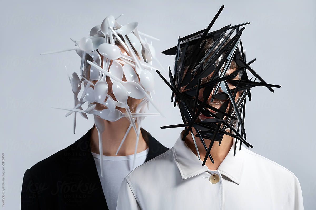 two woman faces fully covered with plastic spoons and knives