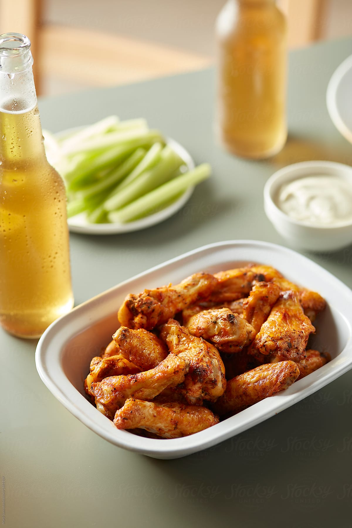 Hot spicy chicken wings with celery and beer.
